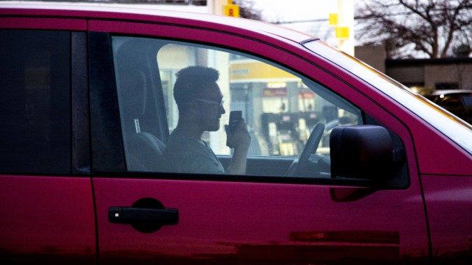 A man talks on a phone in a car at the corner of Federal Boulevard and Florida Avenue, Jan. 16, 2020. 