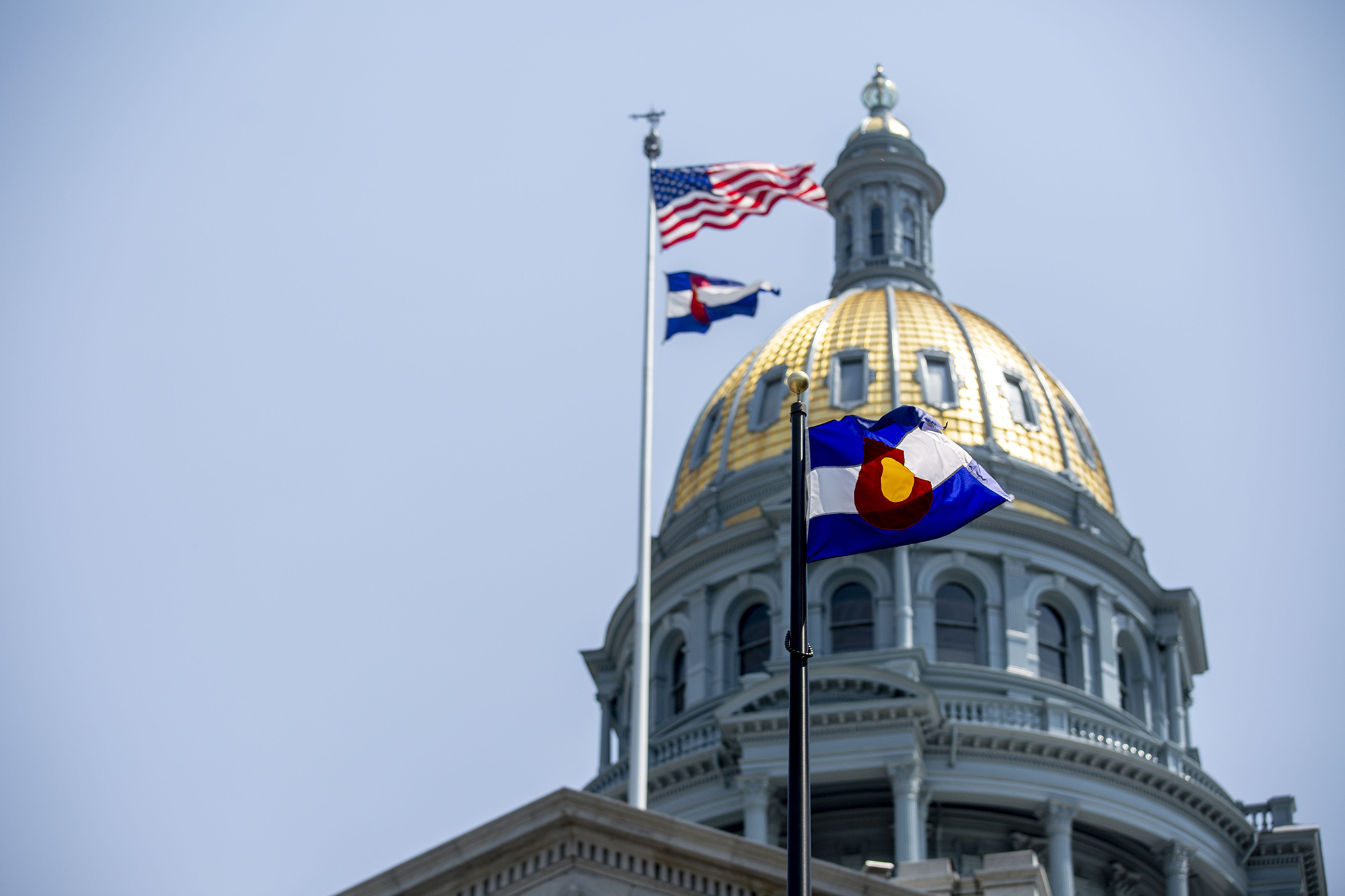 At least two Colorado state flags fly over the State Capitol on Friday, Aug. 14, 2020. 