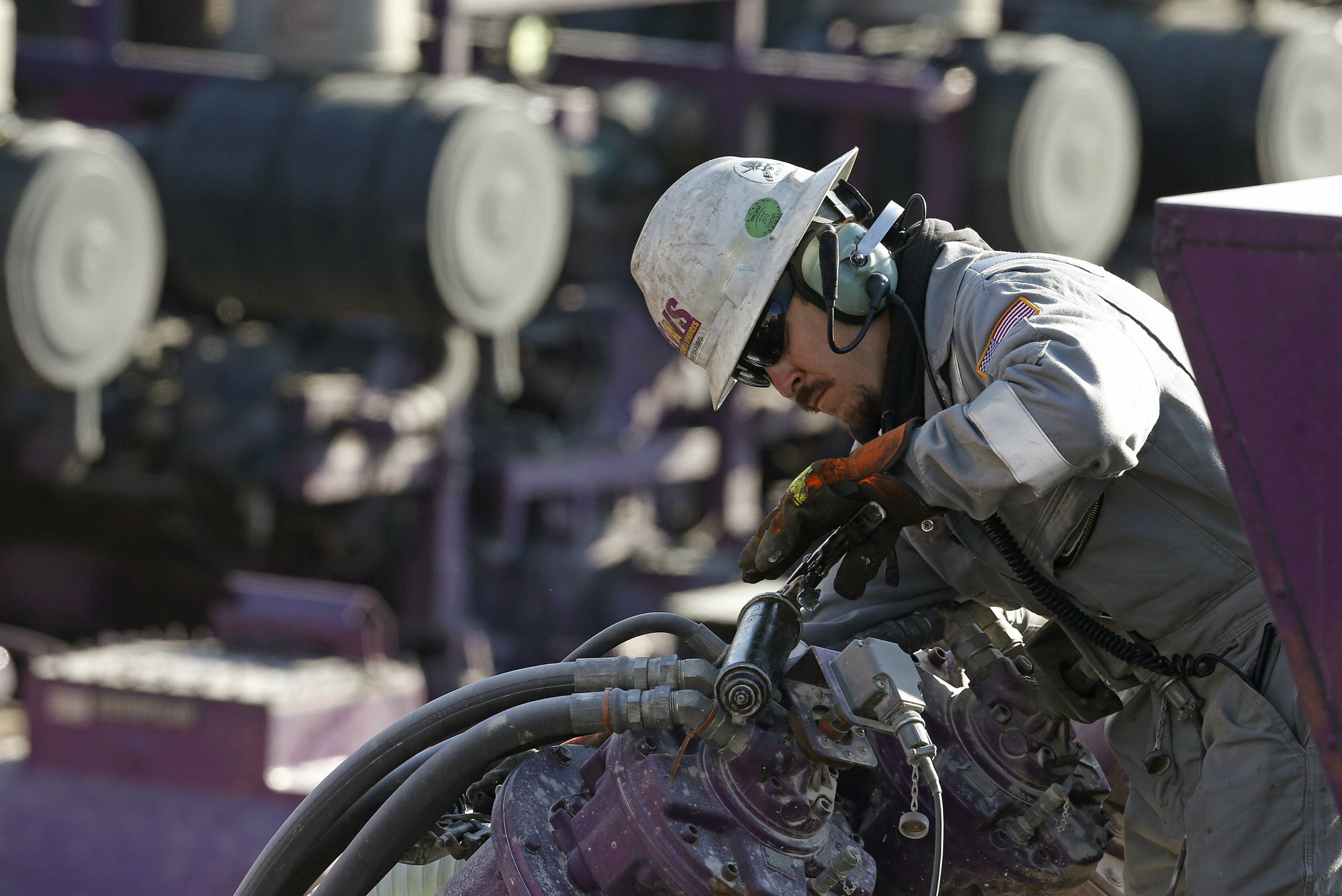 In this March 25, 2014 photo, a worker oils a pump during a hydraulic fracturing operation at an Encana Corp. well pad near Mead, Colo. The National Petroleum Council estimates that up to 80 percent of natural oil wells drilled in the next decade will require hydraulic fracturing.
