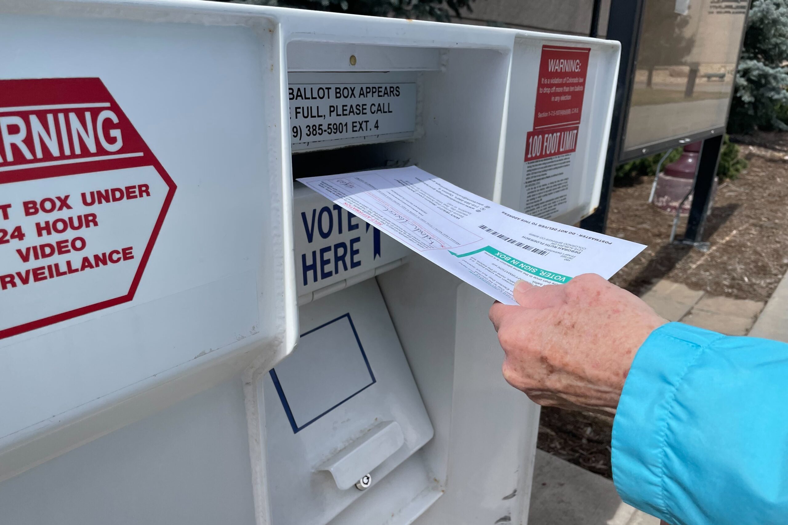 A voter drops off their ballot at the Centennial Hall drop box in downtown Colorado Springs on Tuesday, April 4, 2023.