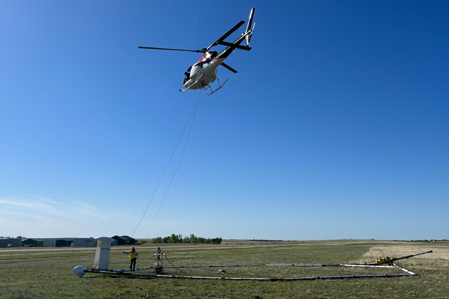 A helicopter carrying a sensing device prepares to take take off near Peyton to gather data for a groundwater study. (June 8, 2023)