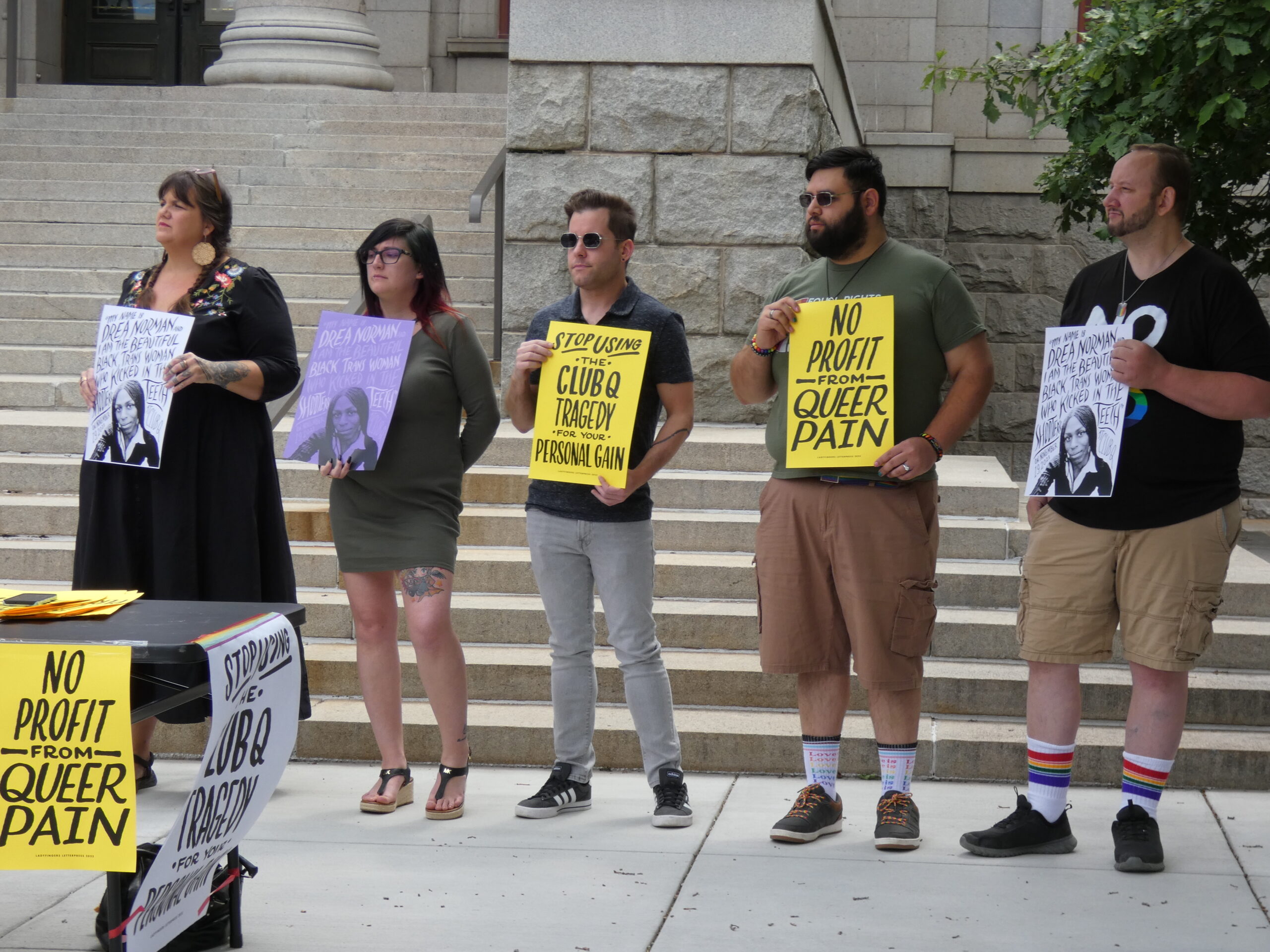 left to right: Erika Righter, Ashtin Gamblin, John Arcediano, Jancarlos Dell Valle, and James Slaugh hold signs during a press conference in front of Colorado Springs City Hall on June 20, 2023.